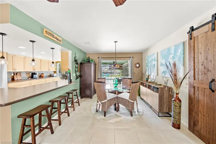 Tiled dining room featuring a barn door