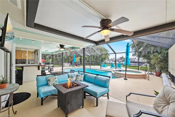 View of patio / terrace with a lanai and an outdoor living space with a fire pit