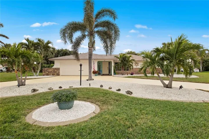 View of front facade featuring a front lawn and a garage