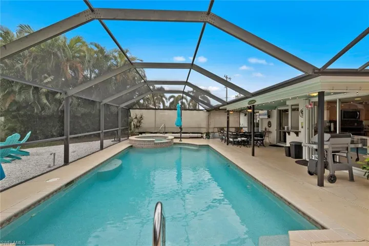 View of swimming pool featuring a lanai, an in ground hot tub, and a patio