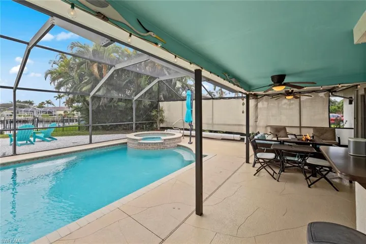 View of pool featuring a lanai, a patio area, and an in ground hot tub