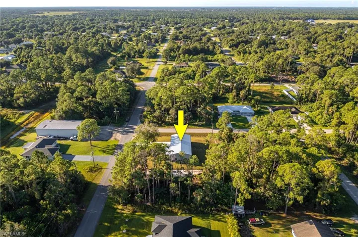 Aerial view of property and surrounding area with nearby suburban area