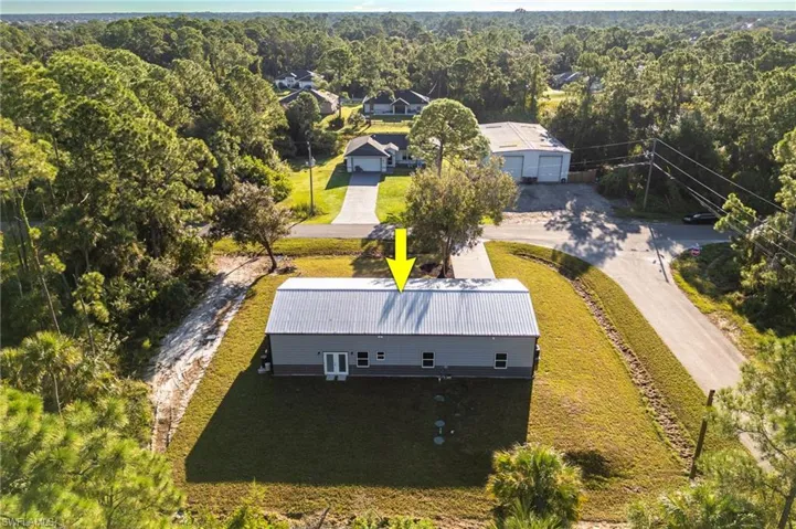 Aerial view of property and surrounding area featuring a heavily wooded area