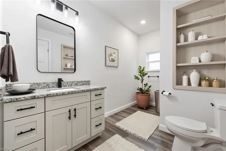Bathroom with vanity, dark wood-type flooring, and recessed lighting