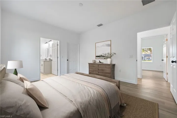 Bedroom featuring wood finished floors and ensuite bathroom