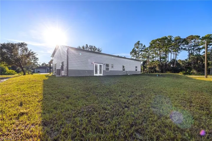 Back of property with a lawn and french doors