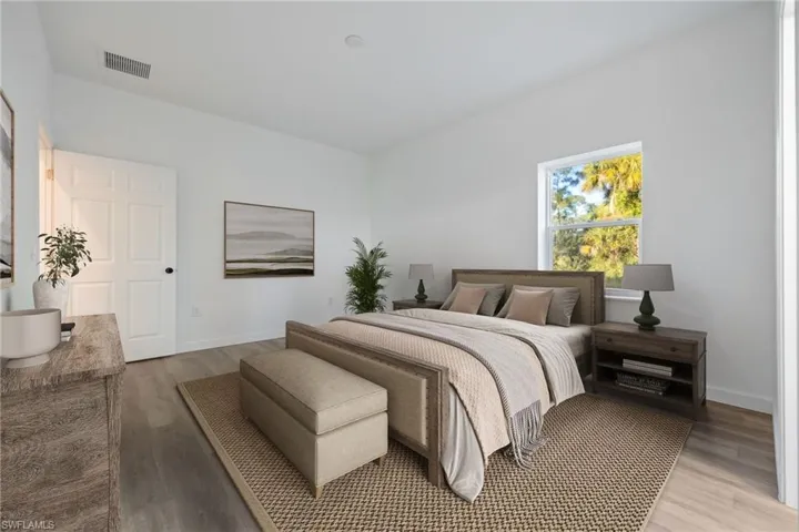 Bedroom with wood finished floors and baseboards