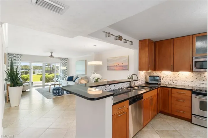 granite counters and stainless appliances with breakfast bar kitchen