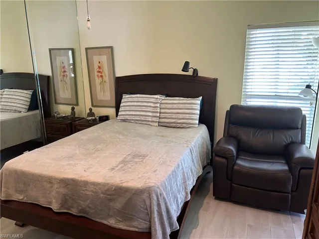 Bedroom featuring  light wood-type flooring, volume ceiling