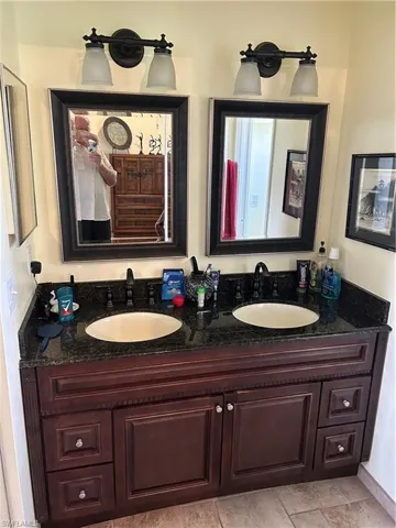 Bathroom with double vanity and tile patterned floors