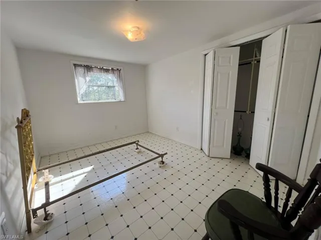 Bedroom featuring light floors and baseboards