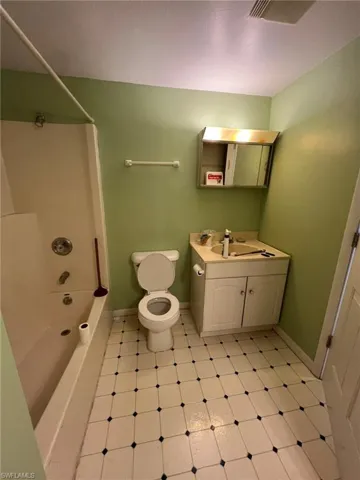 Full bathroom featuring shower / washtub combination, toilet, vanity, and baseboards