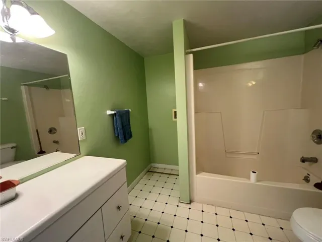 Full bath featuring shower / bathtub combination, vanity, toilet, and tile patterned floors