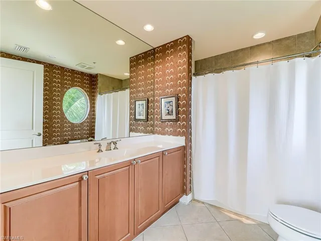 Full bath with vanity, light tile patterned flooring, recessed lighting, and a shower with shower curtain
