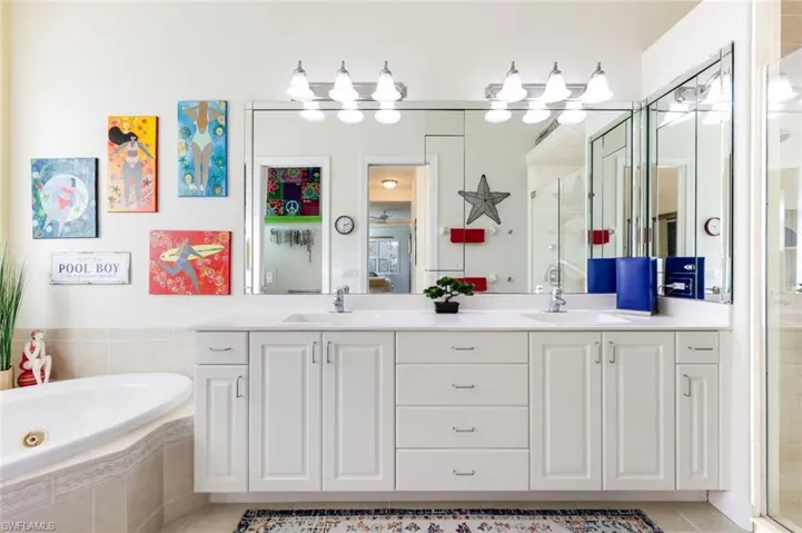 Primary bathroom with extended dual vanity, walk-in shower, and tasteful tile finishes. After a long day, relax in the tub while enjoying your favorite glass of wine.