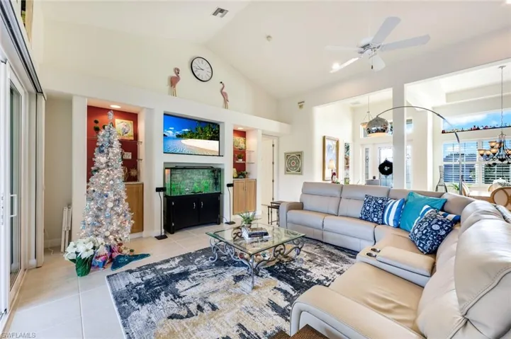 Open living space with volume ceilings, built-in niches and direct access to the lanai through sliding glass doors.