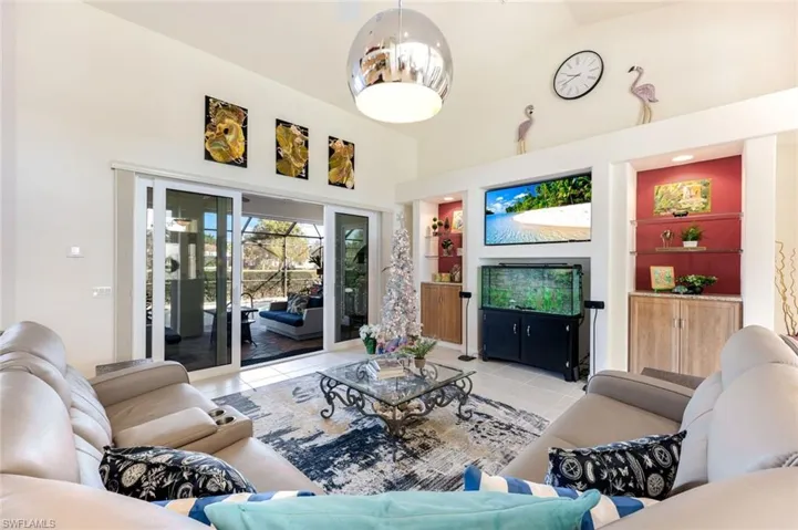 Comfortable living room featuring built-in shelving, a media wall, and sliding glass doors leading to the outdoor living area.