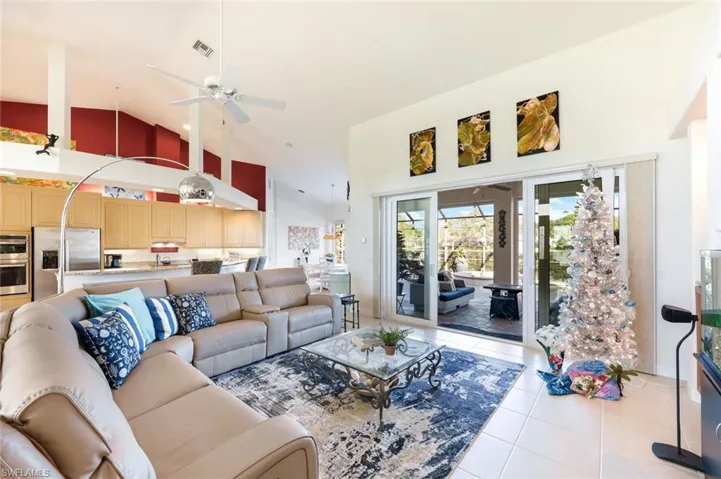 Spacious great room with open flow to the kitchen and sliding glass doors leading to the screened outdoor living area. A perfect place to gather with friends and family while watching your favorite sports.
