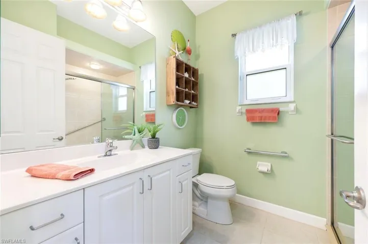 Light-filled den or home office with built-in shelving, neutral flooring, and sliding glass doors to the lanai. this room has a closet and could easily be converted to another bedroom.