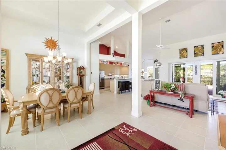 Dedicated dining area with soaring ceilings, open to the kitchen and living area with abundant natural light from surrounding windows.