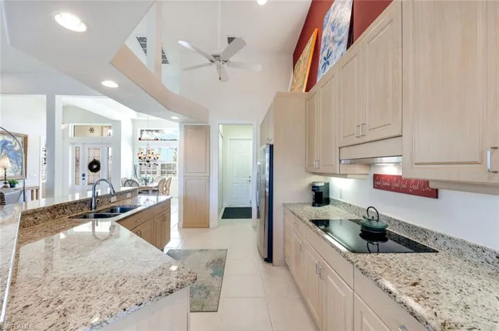 Bright kitchen with expansive granite counters, generous storage, and an efficient galley-style layout. Plenty of space for the chef in the family to prepare favorite meals.