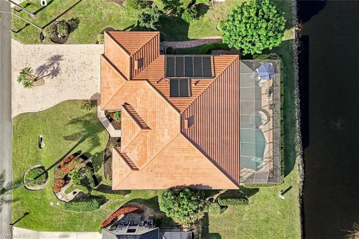 Expansive aerial view showcasing the surrounding community, waterways, and lush green spaces. Located on one of the premier streets in Spanish Wells.