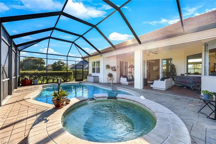 Screened pool area with spacious paver decking and multiple access points to the home’s interior living spaces.