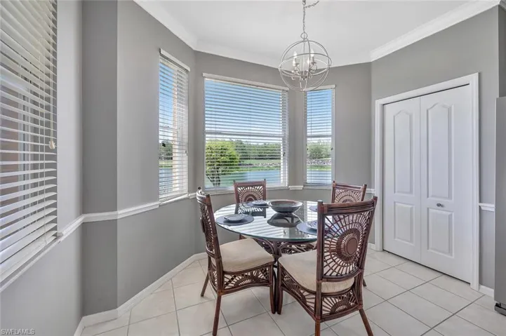 Dining area with a chandelier, healthy amount of natural light, light tile patterned floors, and ornamental molding