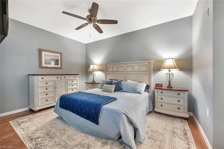 Bedroom featuring wood finished floors, baseboards, and a ceiling fan