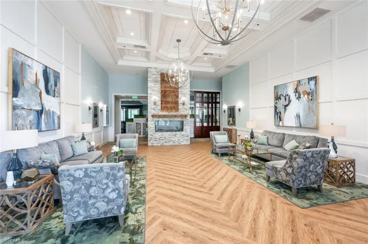 Living room featuring a chandelier, coffered ceiling, recessed lighting, beamed ceiling, and a decorative wall