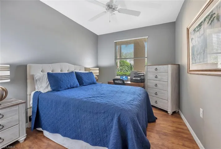 Bedroom featuring baseboards, wood finished floors, and a ceiling fan