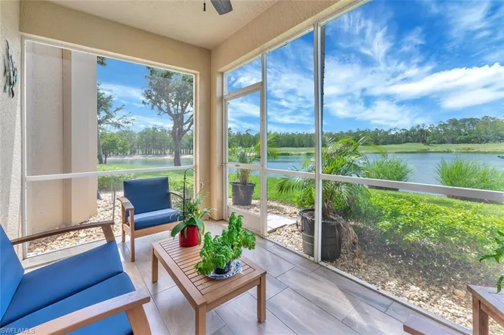 Sunroom with a water view, view of wooded area, outdoor lounge area, and a ceiling fan
