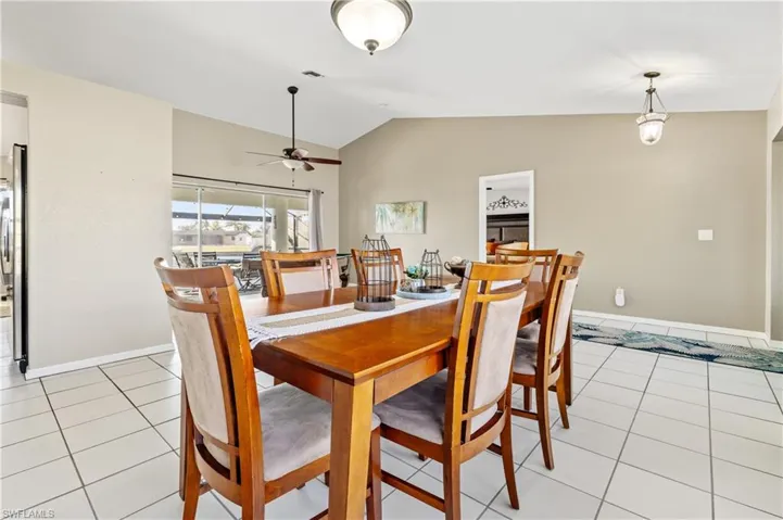 Dining room featuring lofted ceiling, light tile patterned flooring, and a ceiling fan