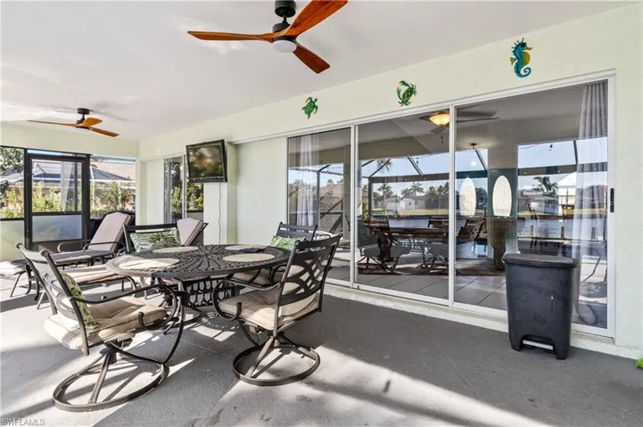 View of patio / terrace featuring outdoor dining area, a sunroom, and ceiling fan