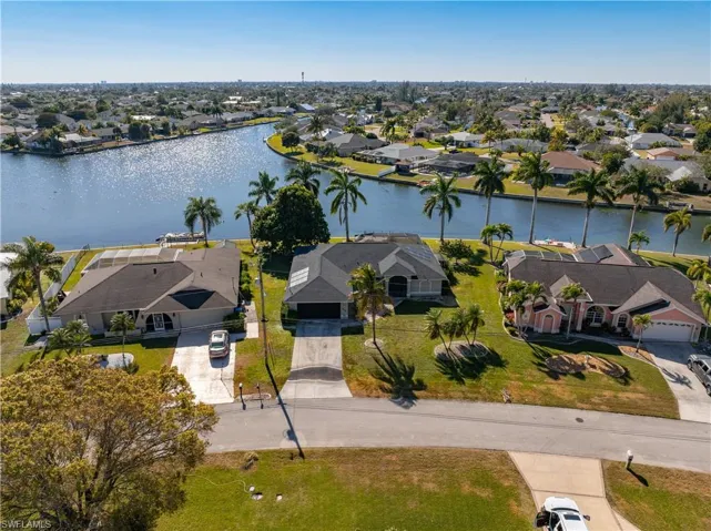 Aerial perspective of suburban area featuring a nearby body of water