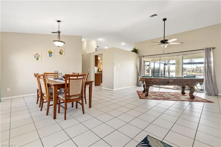 Dining space featuring pool table, lofted ceiling, light tile patterned flooring, and ceiling fan