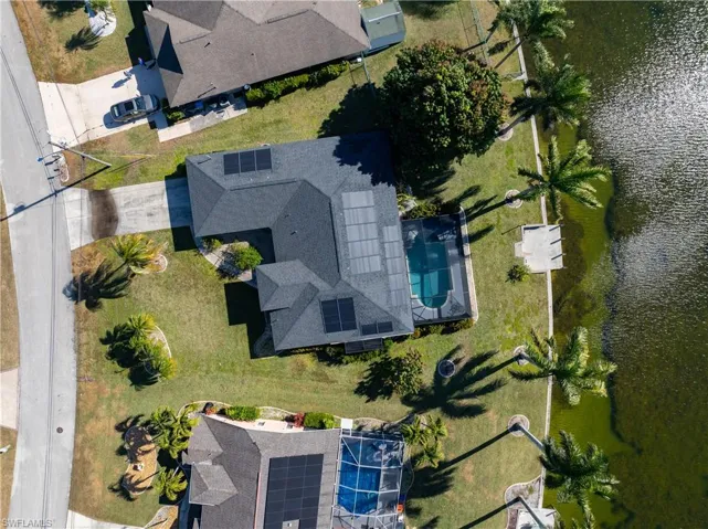 View from above of property with a nearby body of water and a pool