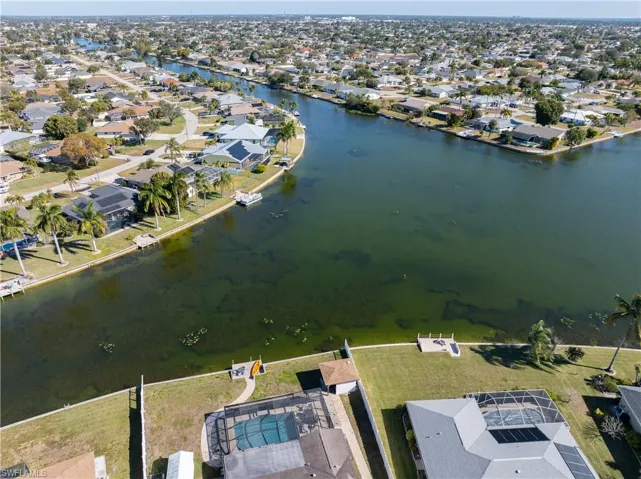 Aerial view of property and surrounding area with nearby suburban area and a large body of water
