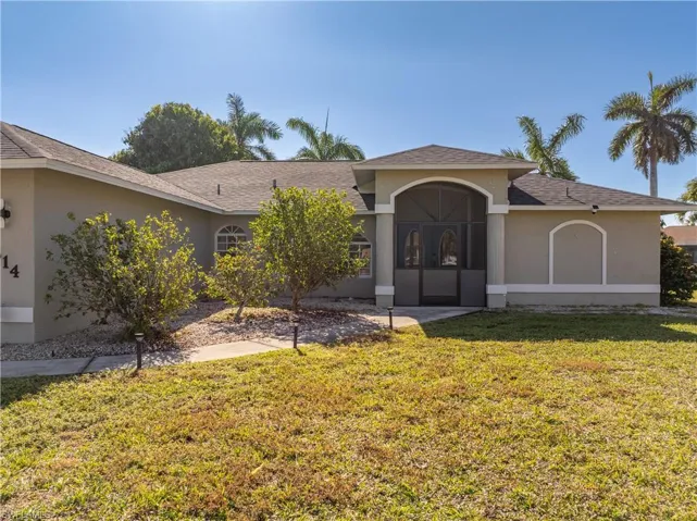 View of front of house with stucco siding, a front lawn, and a shingled roof