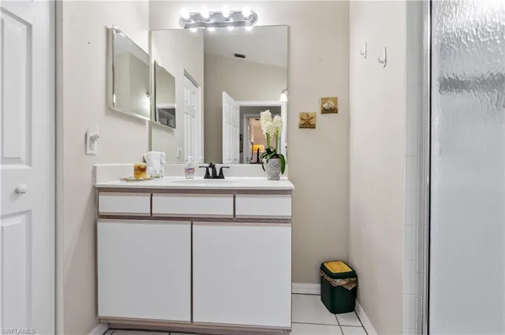 Full bath with vanity and light tile patterned floors