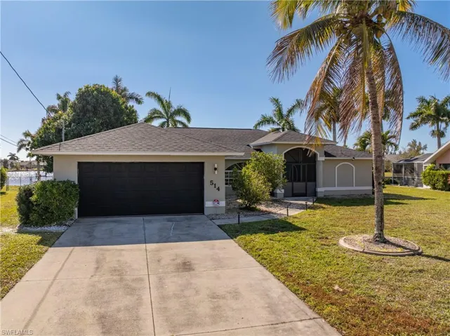 Ranch-style home featuring stucco siding, a front yard, driveway, a garage, and a shingled roof