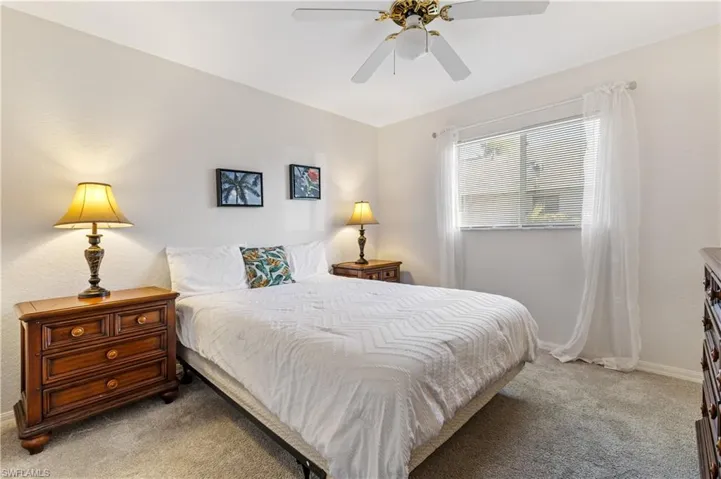Bedroom with light colored carpet and ceiling fan