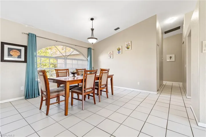 Dining area with vaulted ceiling and light tile patterned floors