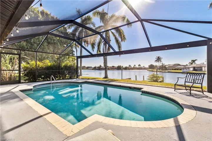 Outdoor pool with a lanai, a water view, a patio area, and a sunroom