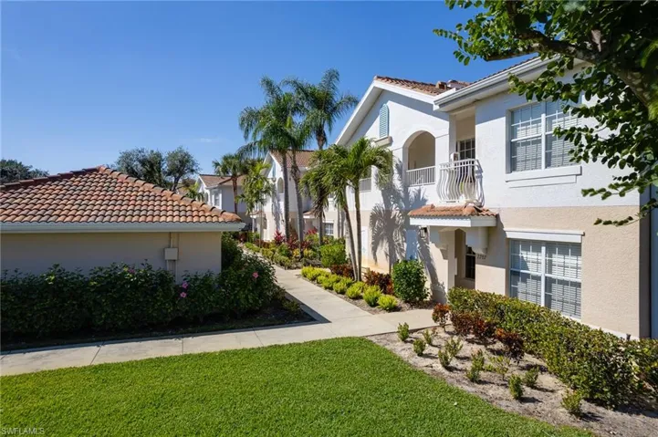 View of front of property with a balcony and a front yard