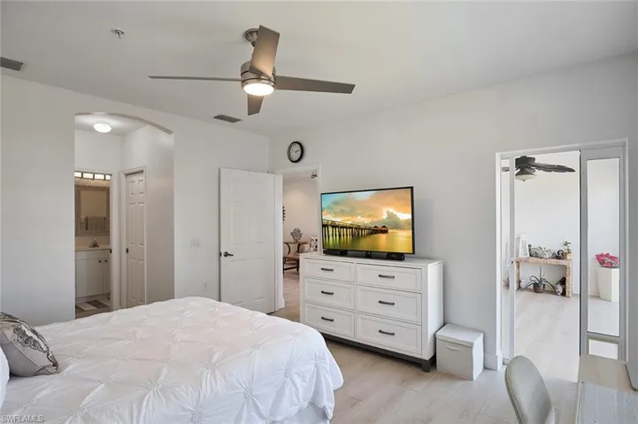 Bedroom with ceiling fan, ensuite bathroom, and light hardwood / wood-style floors