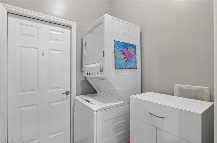 Laundry room featuring stacked washing machine and dryer
