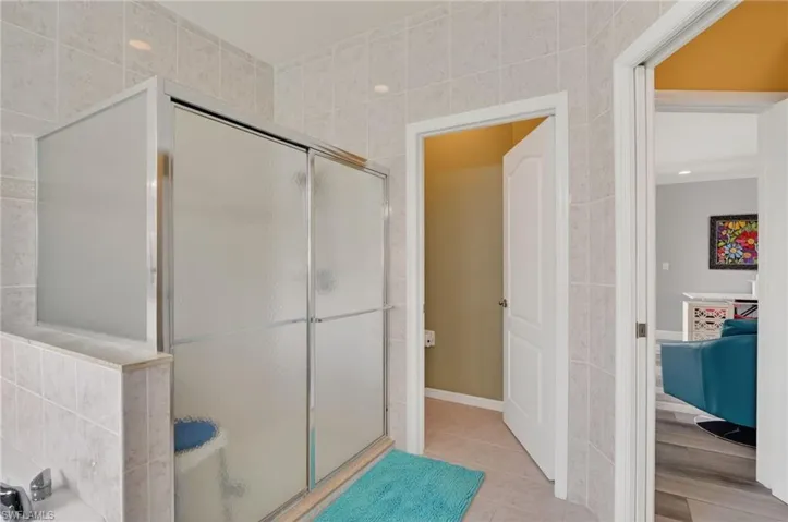 Full bath featuring a stall shower, tile patterned flooring, and tile walls