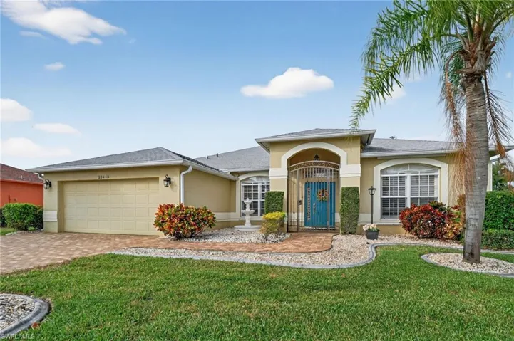 Single story home with stucco siding, a front yard, a garage, and paver driveway. Turnkey Furnished