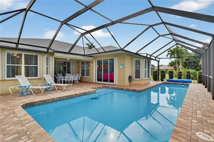 Swimming pool featuring a sunroom, a lanai, and a patio